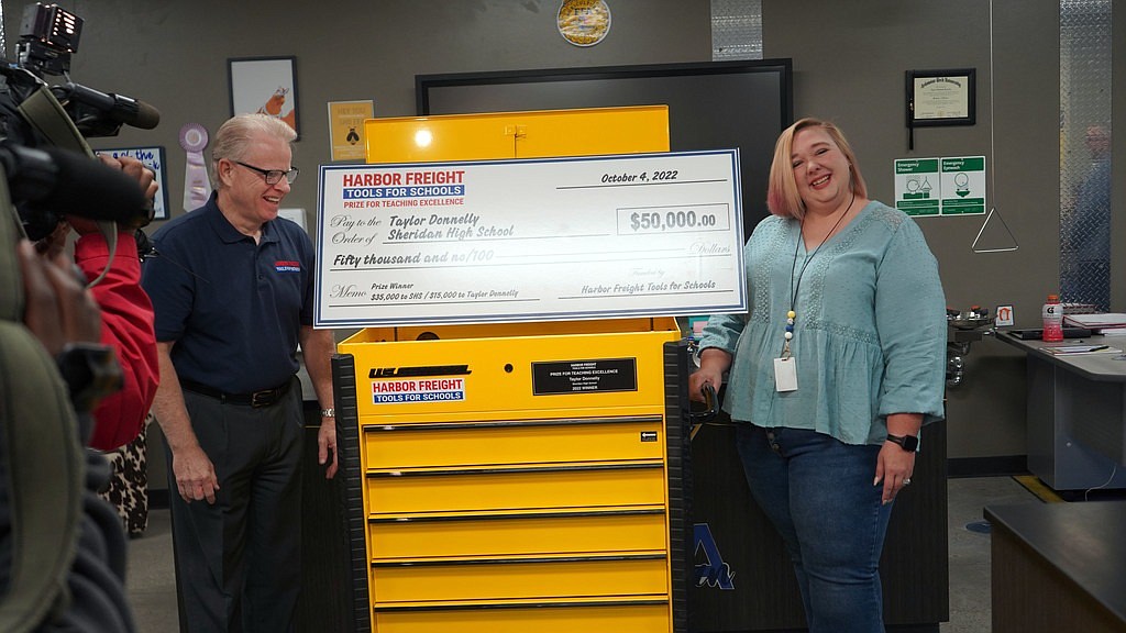 Sheridan High School teacher Taylor Donnelly (right), was surprised last week with a presentation from Harper Freight for a $50,000 check after begin chosen as the Harbor Freight Tools for Schools Prize for Teaching Excellence winner. Donnelly will recieve $15,000 and SHS will receive $35,000 for its skilled trades programs.  Also, pictured is Harbor Freight representative David Randall.
