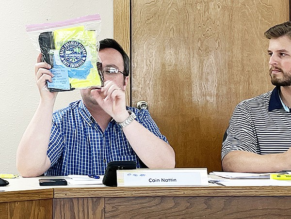 Sheridan Mayor Cain Nattin shows the supplies available for the Adopt-A-Street program during the May Clean City Taskforce meeting as Dakota Hedden, chairman of the Clean City Taskforce looks on.  Photo by Gretchen Ritchey