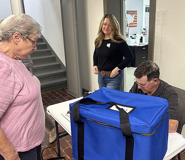 A poll worker checks in the ballots from one of the county’s vote centers. Election Commissioner Charles Jones receives the ballots as fellow commissioner Tanya Diotte observes. Photo by Jacob Palmer