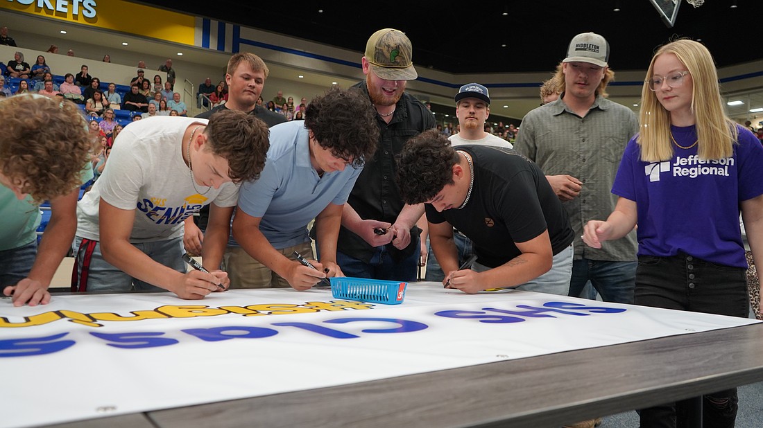 Sheridan High School students sign their names to a poster as part of National Signing Day. (Photo: Courtesy Sheridan School District)