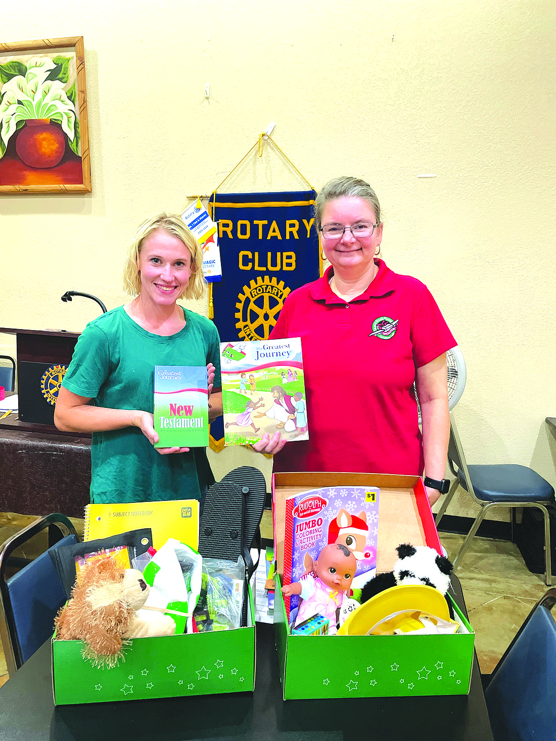Rotarian Madi (left) and Lynn Summit show items that can be found inside an Operation Christmas Child shoebox. (Photo: Gretchen Ritchey)
