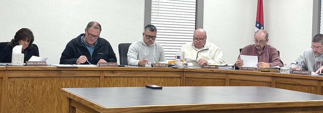 (Left to right) Justice of the Peace Marilyn DeMoss, County Judge Randy Pruitt, JP Mike Nevens, JP Danny Bone, JP Tony Carder, and JP Jason Roshto look over the 2026 Budget as Treasurer Tim Stuckey reads the annual budget ordinance aloud. (Photo: Gretchen Ritchey)